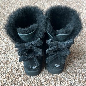 Black UGG boots with corduroy bows.